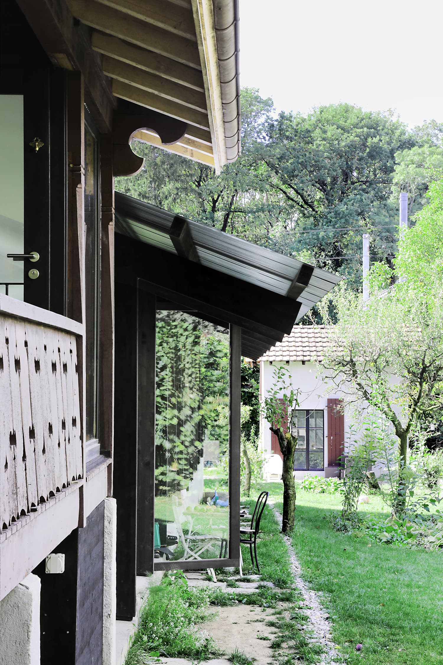 The Permanent Weekend House is a thin and long construction, extending an old chalet through its garden