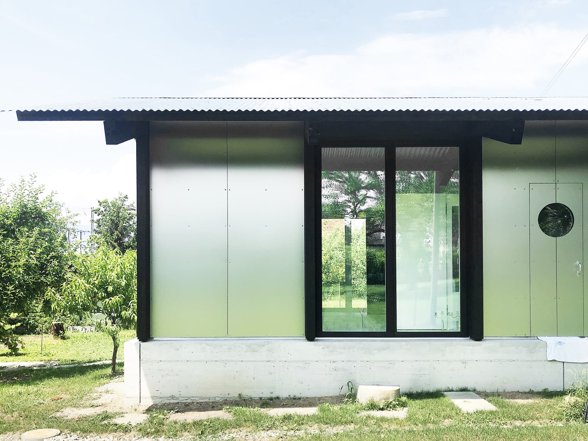 The Permanent Weekend House is a thin and long construction, extending an old chalet through its garden
